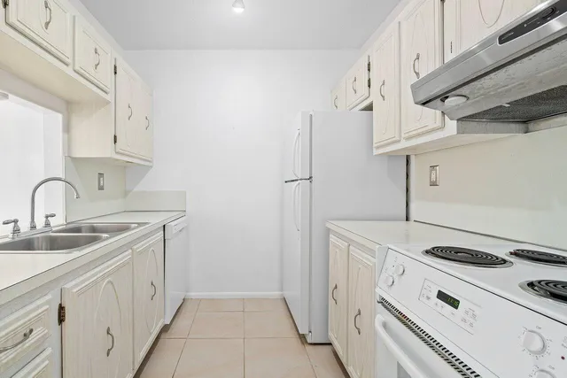 a kitchen with granite countertop white cabinets and sink