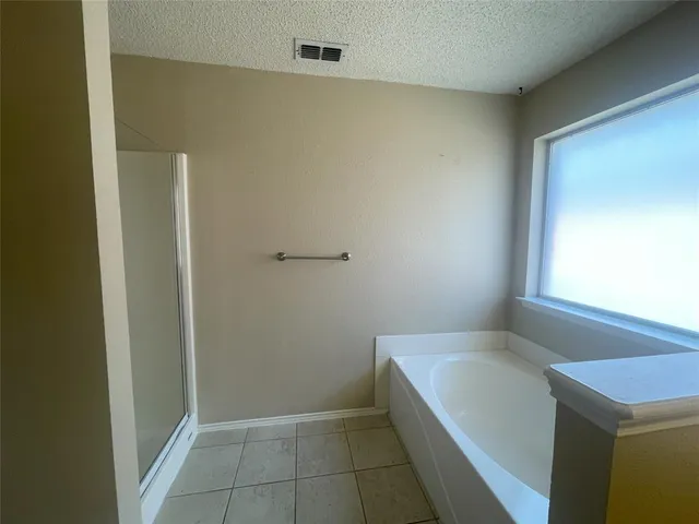 a bathroom with a granite countertop sink and a bathtub
