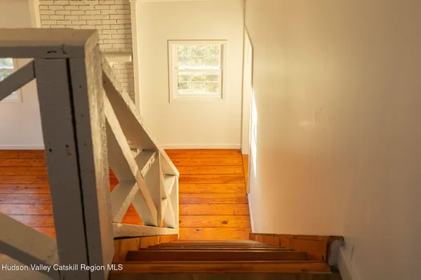 a view of staircase with wooden floor and door