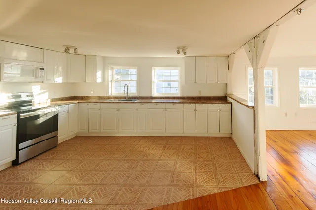 a large kitchen with a stove a sink dishwasher and a refrigerator