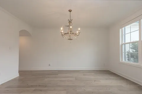 a view of a chandelier in big room and empty room