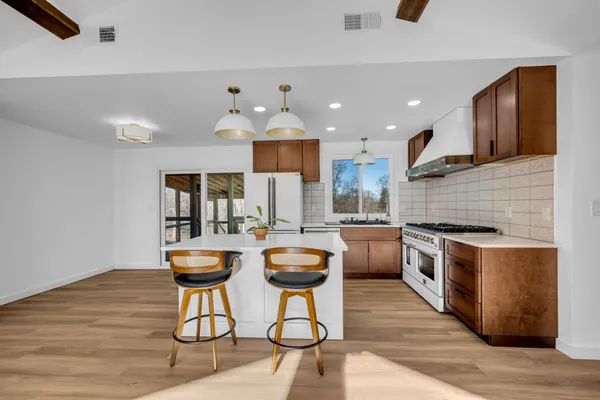 a kitchen with stainless steel appliances granite countertop a stove a sink and a refrigerator