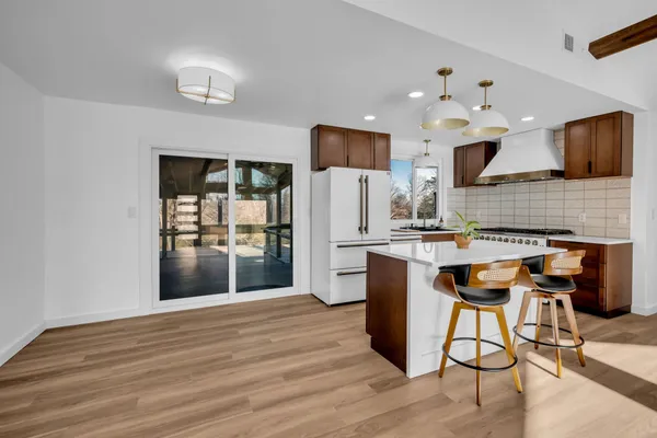 a kitchen with stainless steel appliances kitchen island granite countertop a refrigerator and a stove top oven