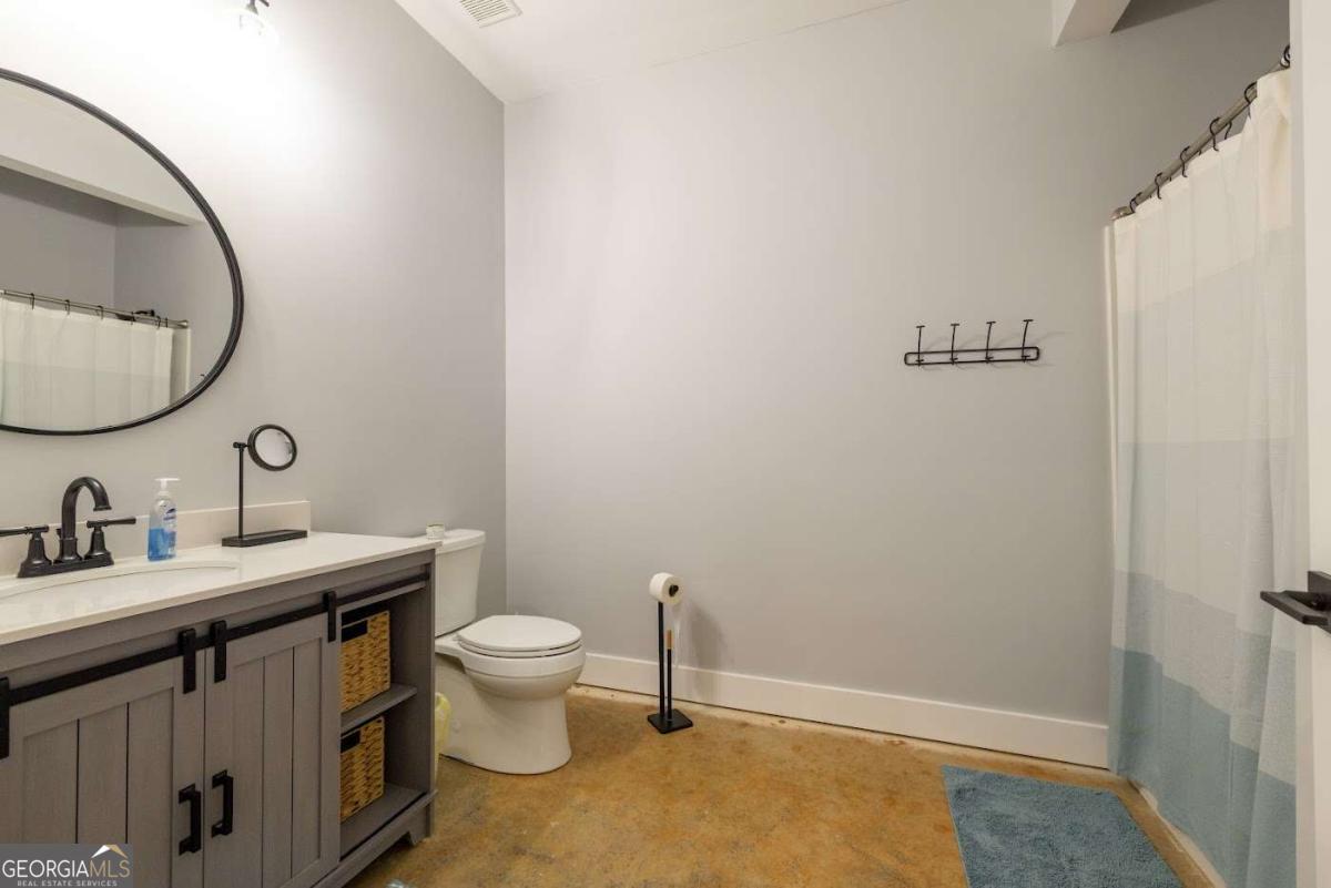 988 Boozer Road Heflin, AL 36264 - Photo 35 of 52 a bathroom with a toilet a sink and mirror