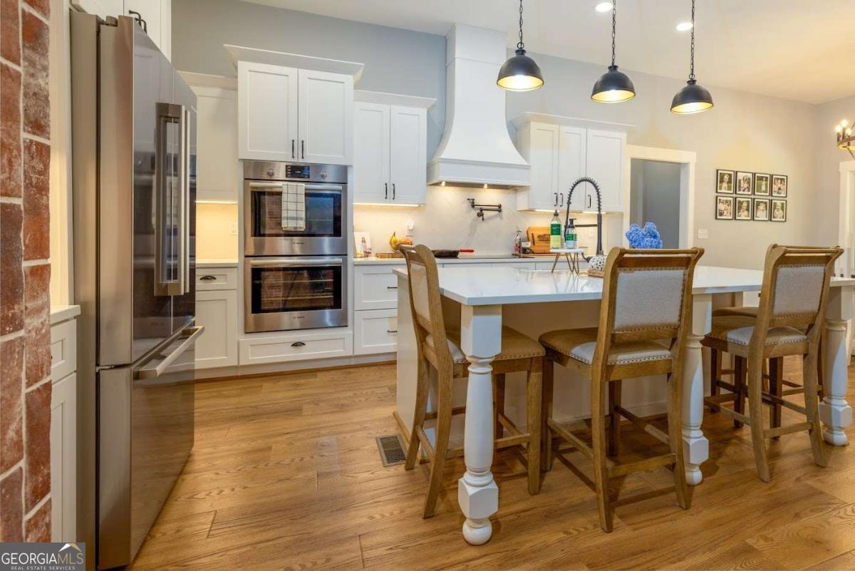 988 Boozer Road Heflin, AL 36264 - Photo 8 of 52 a kitchen with stainless steel appliances a dining table chairs stove and refrigerator