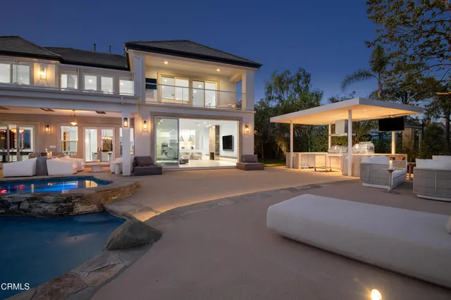 a view of a brick house with large windows and a yard