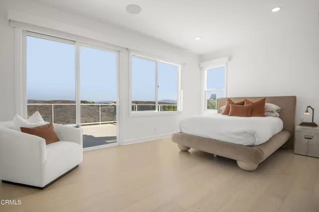 a living room with furniture a flat screen tv and a floor to ceiling window