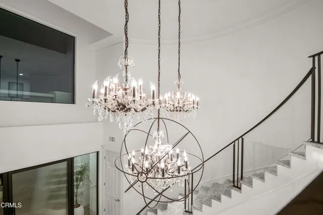 a kitchen that has a lot of white cabinets and stainless steel appliances