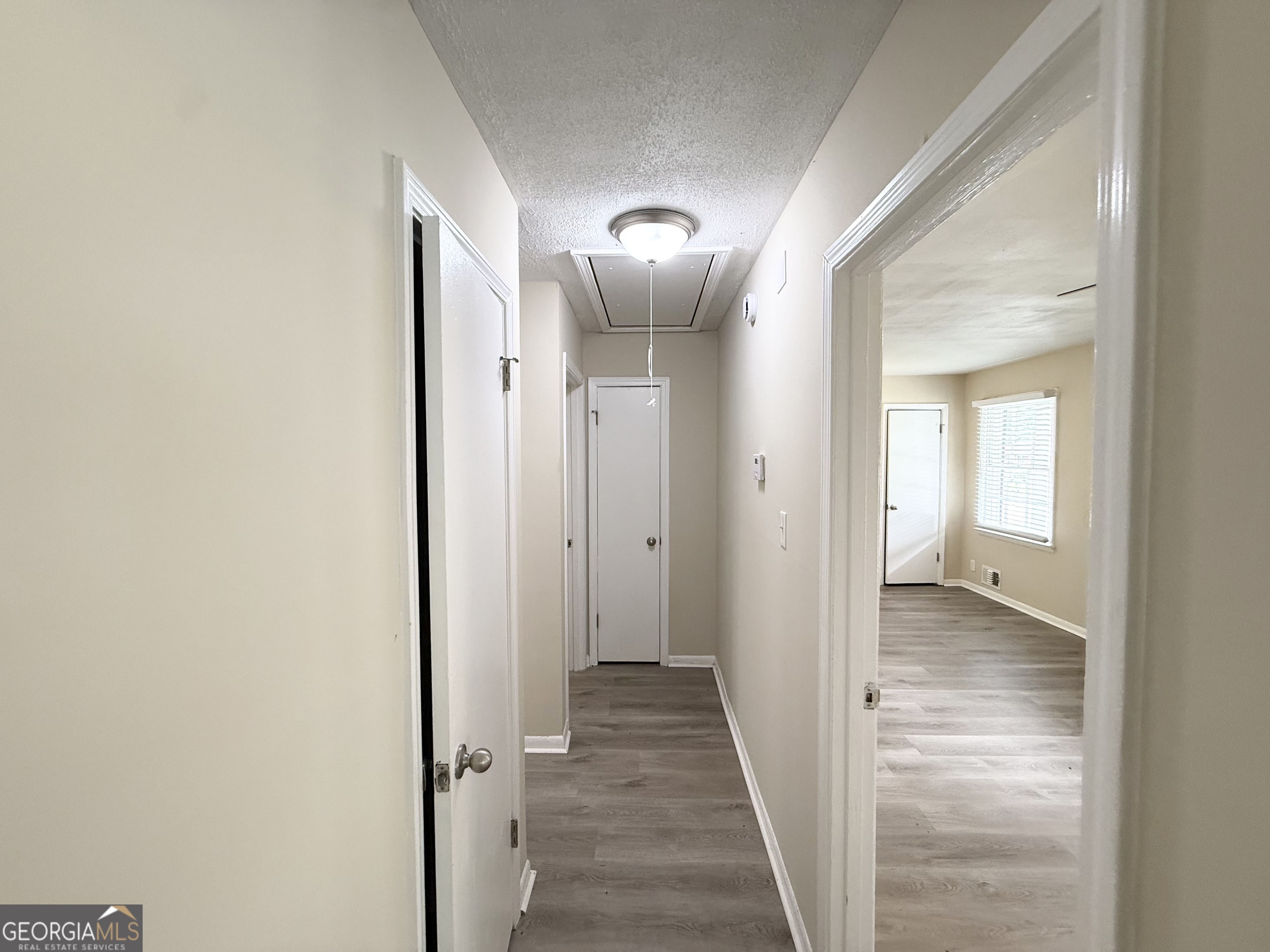 2782 Ocean Valley Road Atlanta, GA 30349 - Photo 10 of 27 a view of a hallway with wooden floor and a bathroom