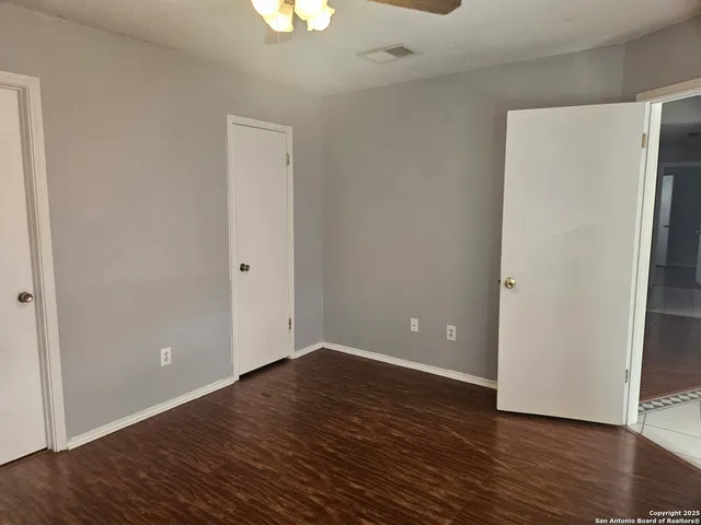 a view of an empty room with wooden floor