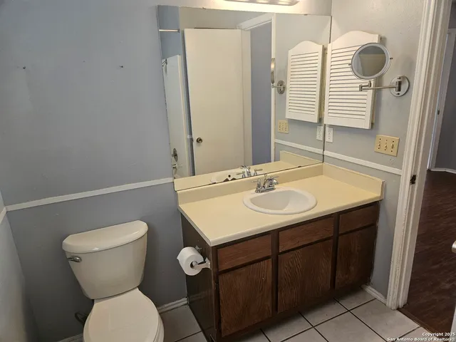 a bathroom with a sink toilet and a mirror