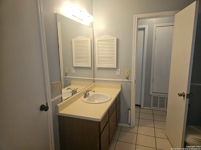 a white toilet sitting next to a wooden cabinet