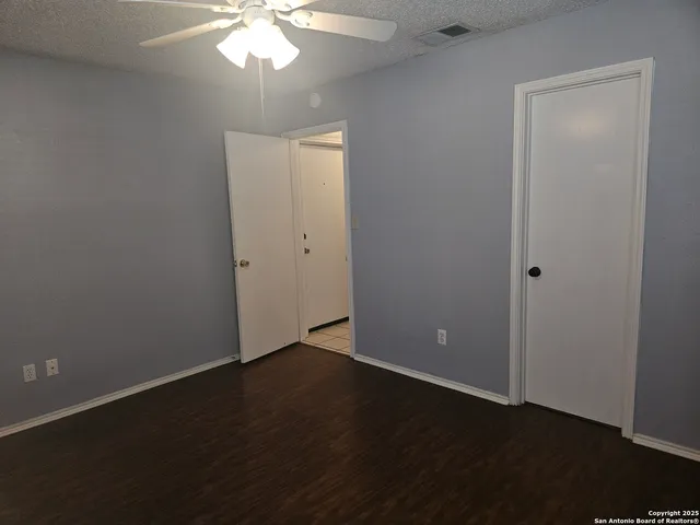 a white house with a small yard and large trees