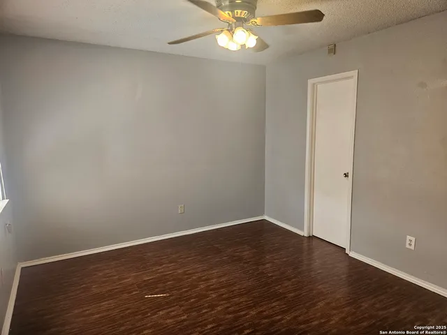 a view of an empty room with wooden floor