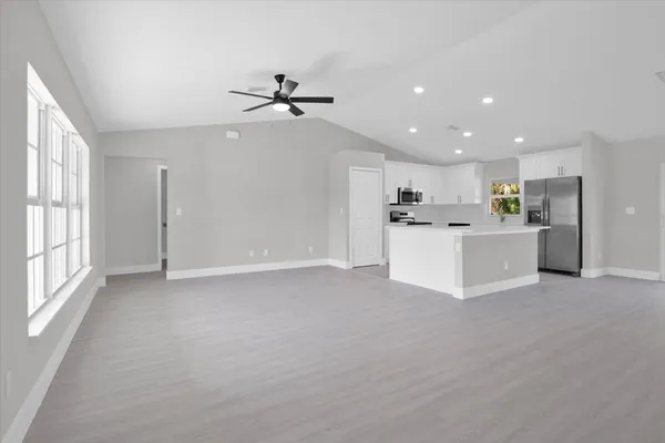 an open kitchen with white cabinets and stainless steel appliances