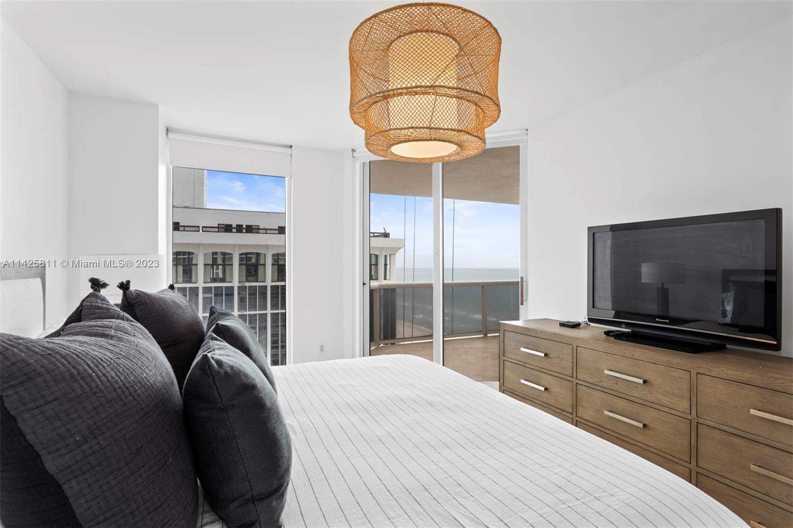 4779 Collins Avenue, Unit 1908 Miami Beach, FL 33140 - Photo 12 of 36 a living room with furniture a flat screen tv and kitchen view