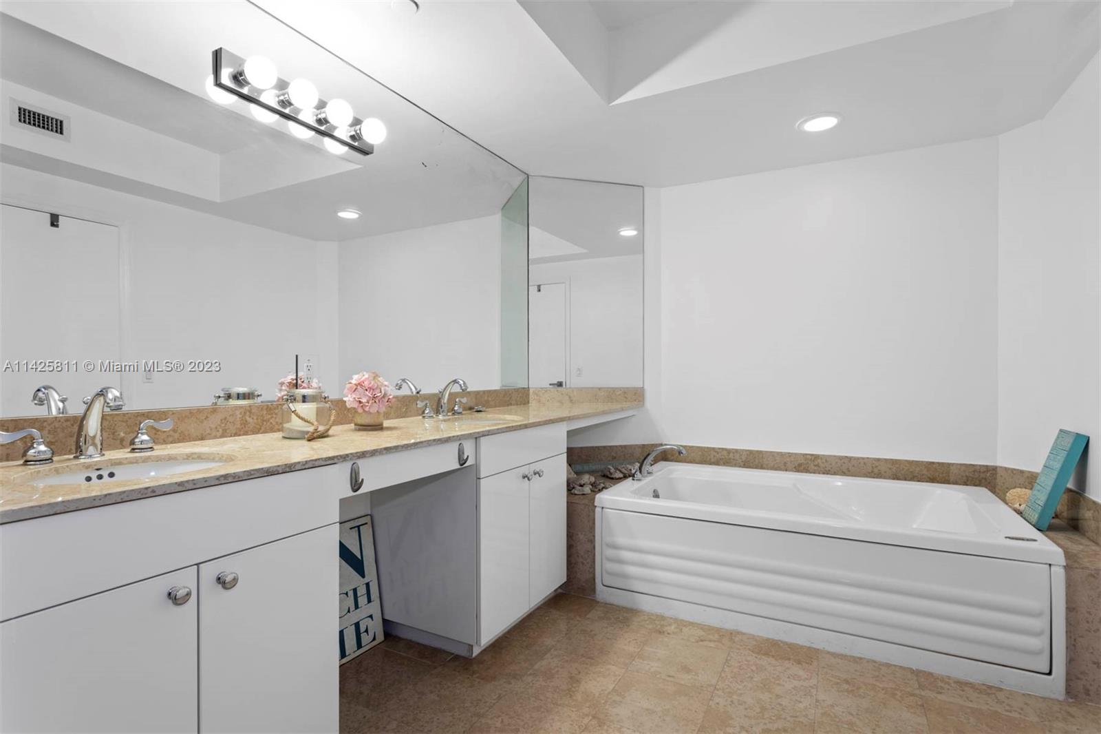 4779 Collins Avenue, Unit 1908 Miami Beach, FL 33140 - Photo 13 of 36 a bathroom with a sink and a mirror