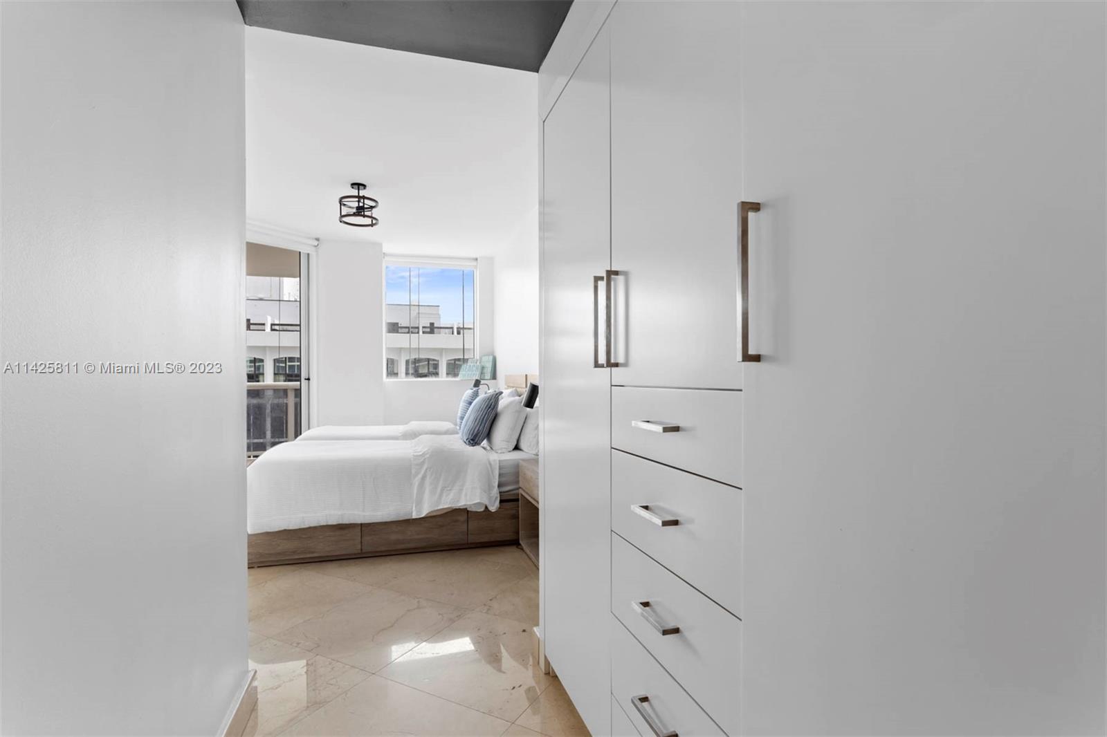 4779 Collins Avenue, Unit 1908 Miami Beach, FL 33140 - Photo 14 of 36 a bedroom with a bed and a night stand