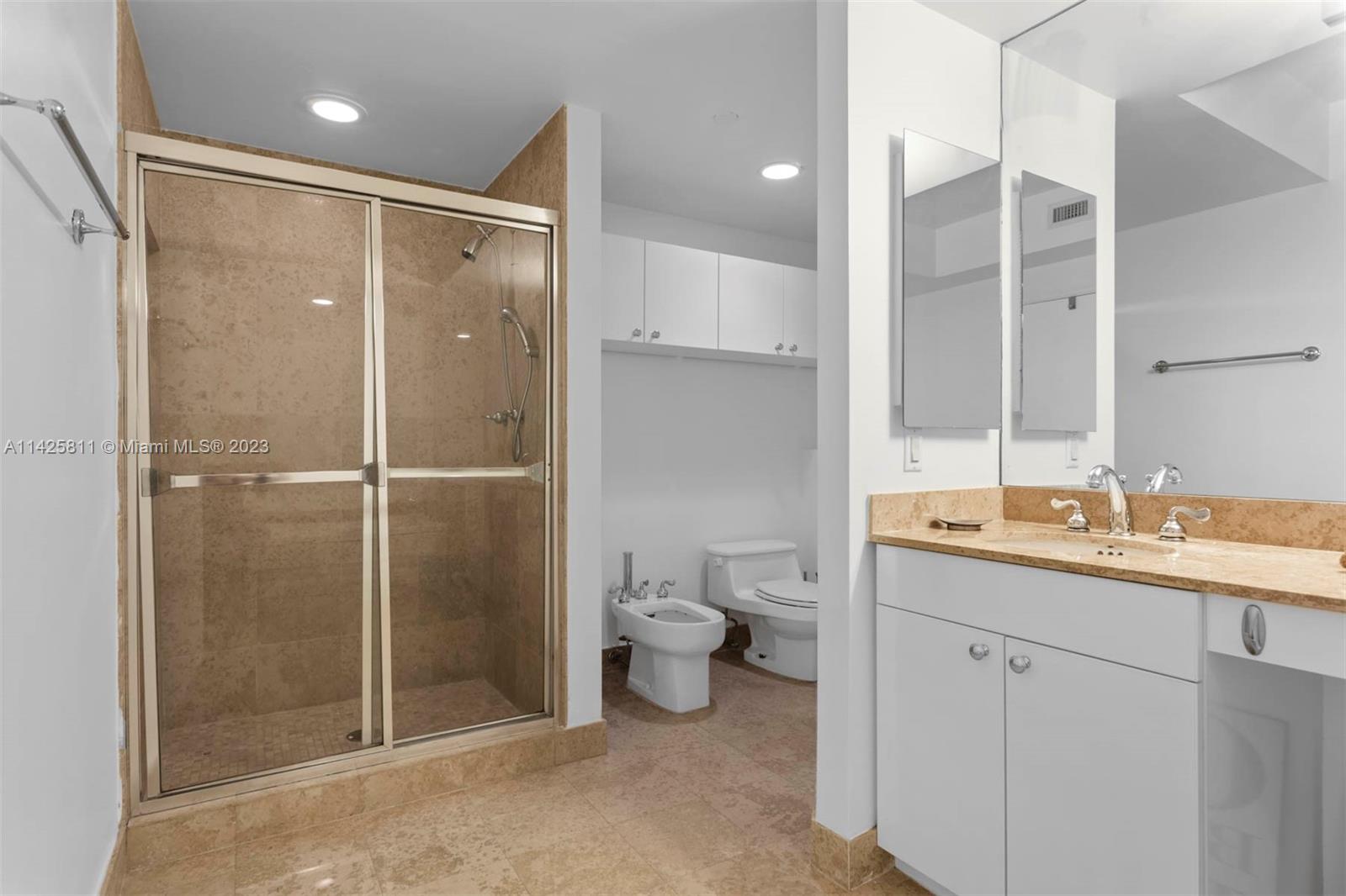 4779 Collins Avenue, Unit 1908 Miami Beach, FL 33140 - Photo 17 of 36 a bathroom with a granite countertop sink a toilet and shower