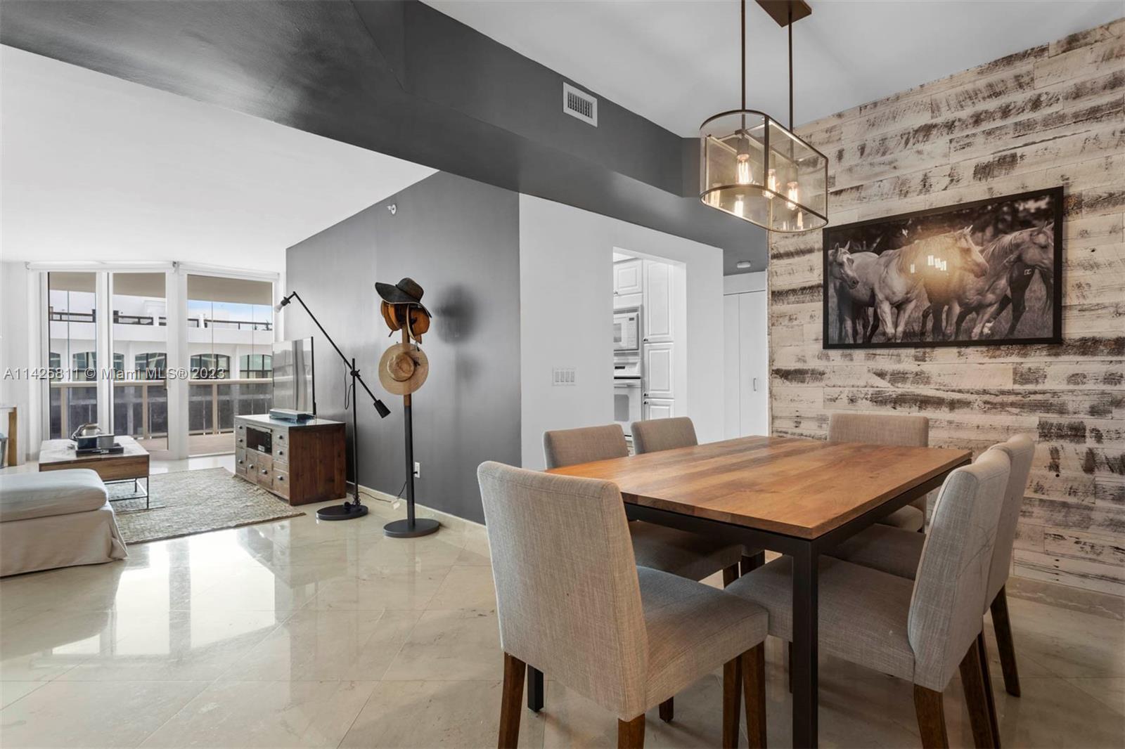 4779 Collins Avenue, Unit 1908 Miami Beach, FL 33140 - Photo 5 of 36 a view of a dining room with furniture wooden floor and chandelier
