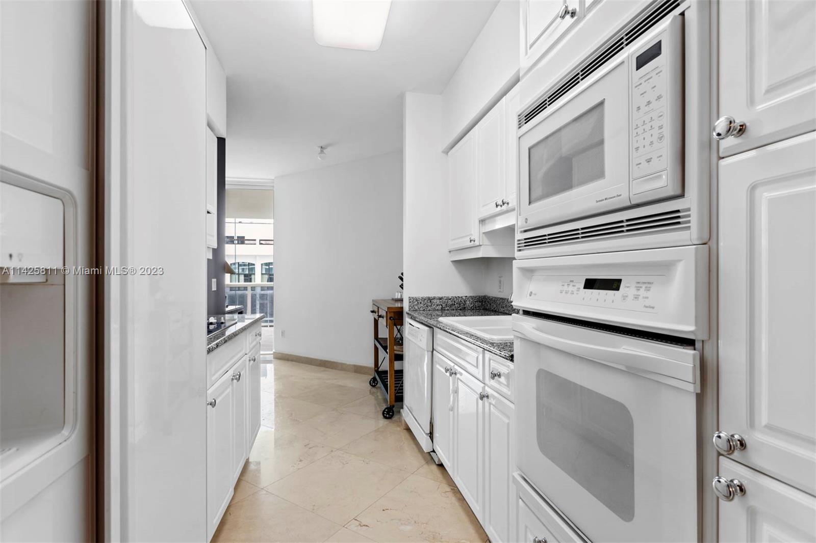 4779 Collins Avenue, Unit 1908 Miami Beach, FL 33140 - Photo 8 of 36 a kitchen with stainless steel appliances granite countertop a stove and a microwave