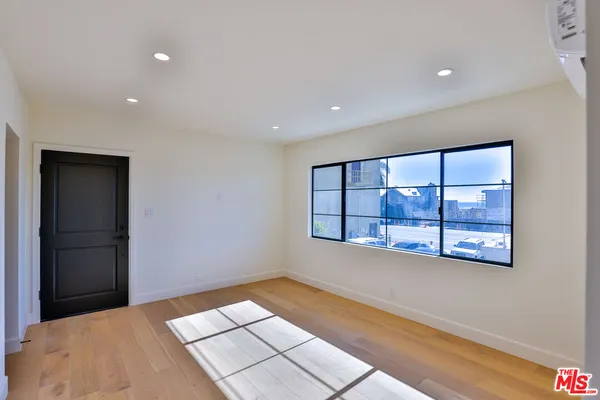 a view of hallway with a large window and wooden floor