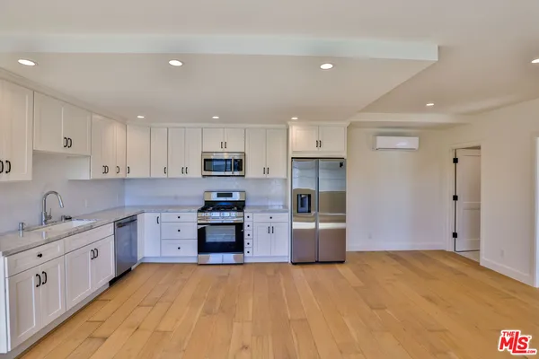 a kitchen with stainless steel appliances granite countertop a refrigerator sink and stove