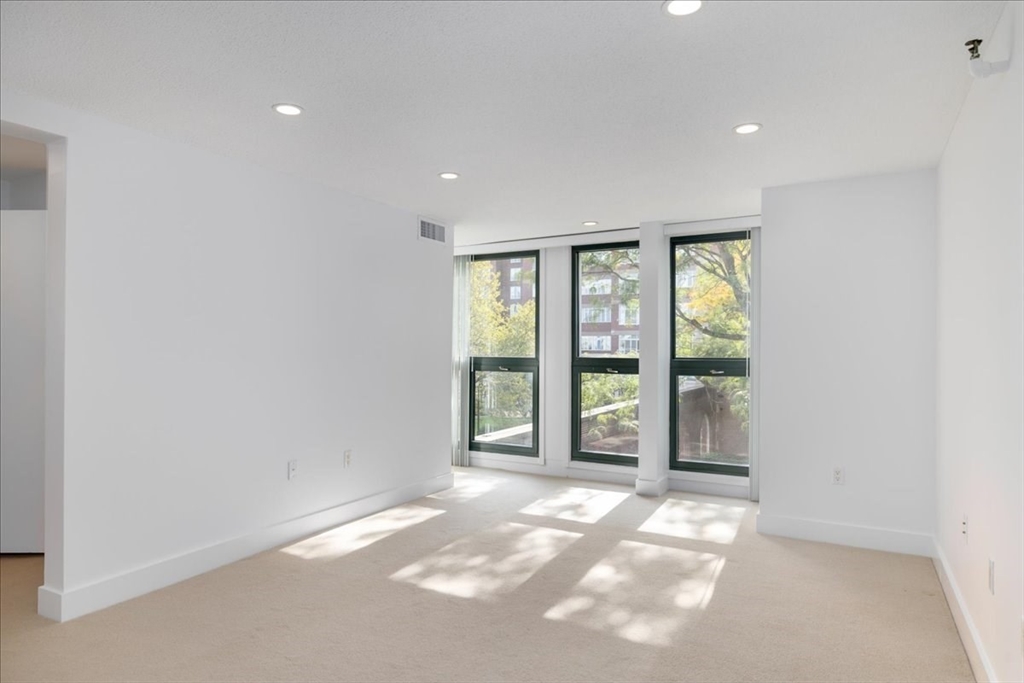 42 8th Street, Unit 5316 Boston, MA 02129 - Photo 2 of 12 an empty room with windows and view of kitchen