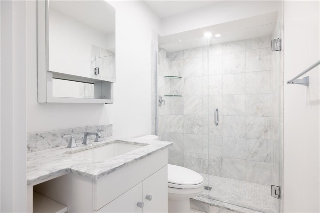 42 8th Street, Unit 5316 Boston, MA 02129 - Photo 4 of 12 a bathroom with a granite countertop sink a toilet and shower