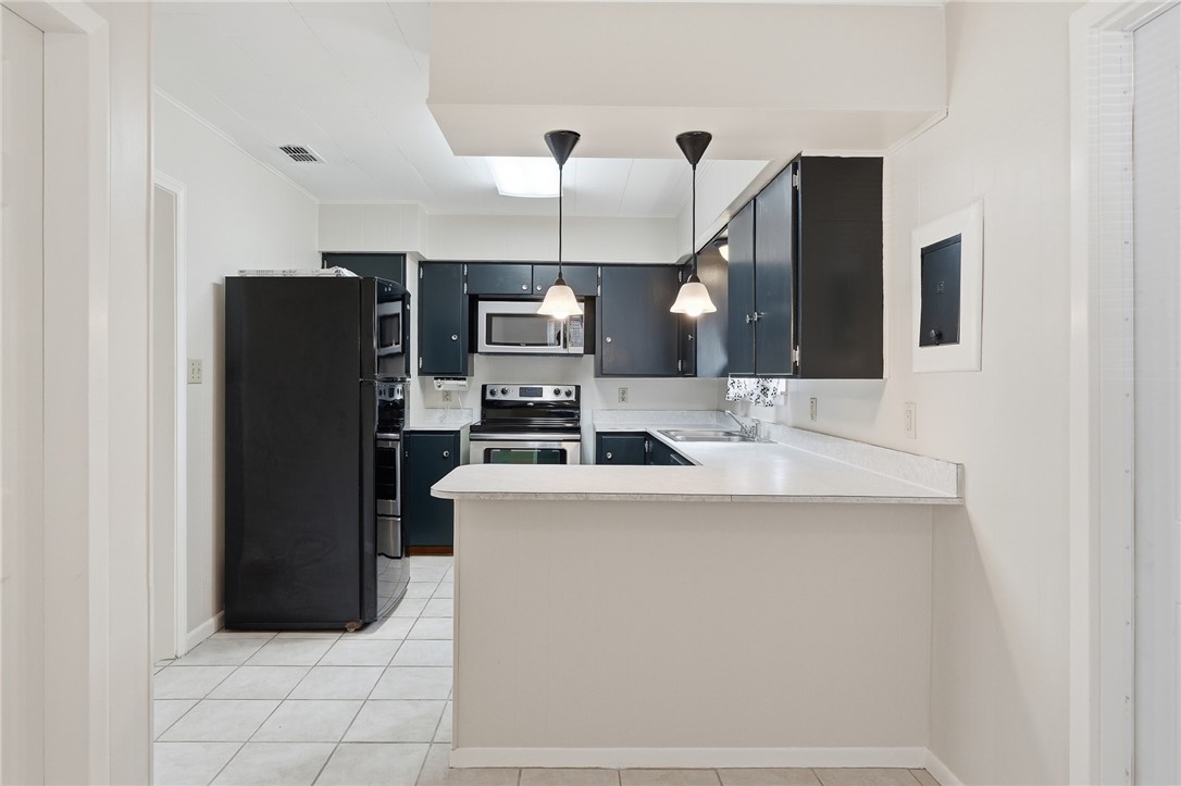 804 Edwards Street Sinton, TX 78387 - Photo 12 of 25 a kitchen with stainless steel appliances a refrigerator and a stove