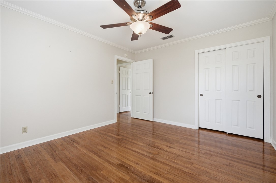 804 Edwards Street Sinton, TX 78387 - Photo 16 of 25 an empty room with wooden floor and a ceiling fan