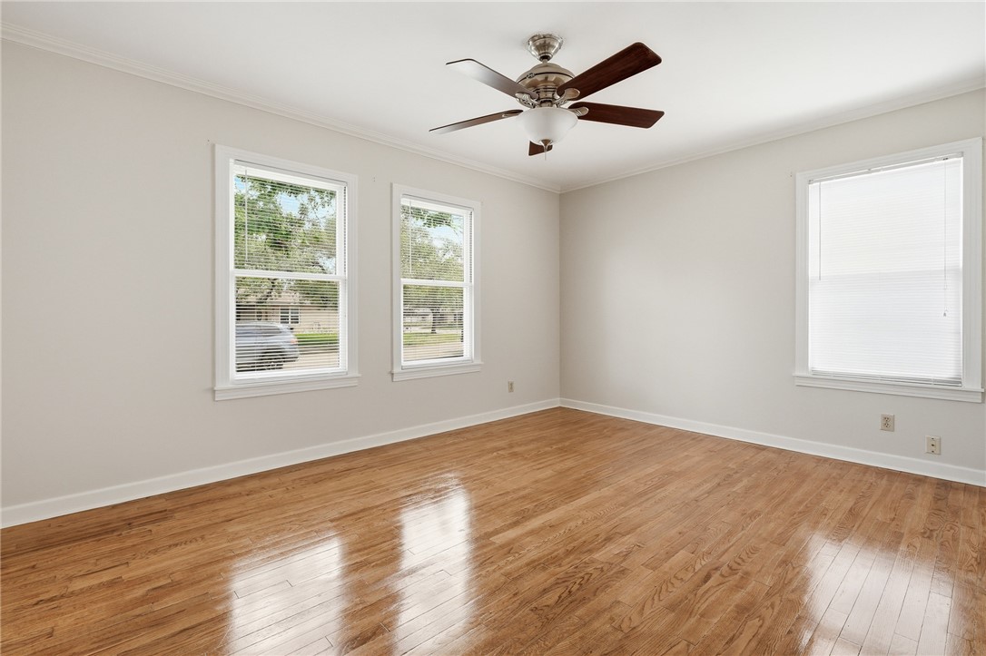 804 Edwards Street Sinton, TX 78387 - Photo 18 of 25 an empty room with wooden floor and windows