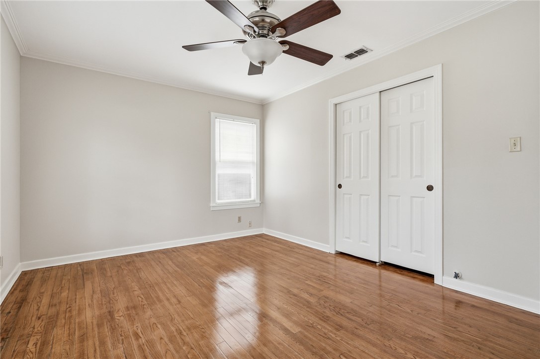 804 Edwards Street Sinton, TX 78387 - Photo 19 of 25 a view of an empty room with wooden floor and a ceiling fan