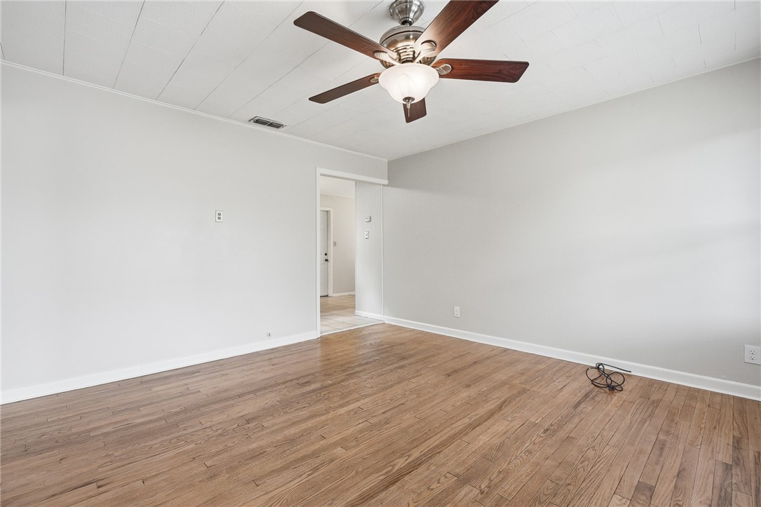 804 Edwards Street Sinton, TX 78387 - Photo 7 of 25 an empty room with wooden floor and fan