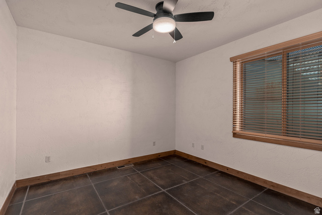 2464 East Granite Way St. George, UT 84790 - Photo 97 of 106 Empty second bedroom with ceiling fan and dark tile patterned flooring