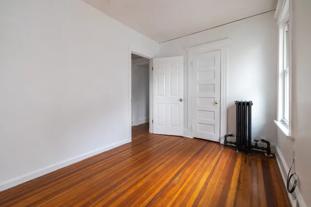 a view of a room with wooden floor and a window