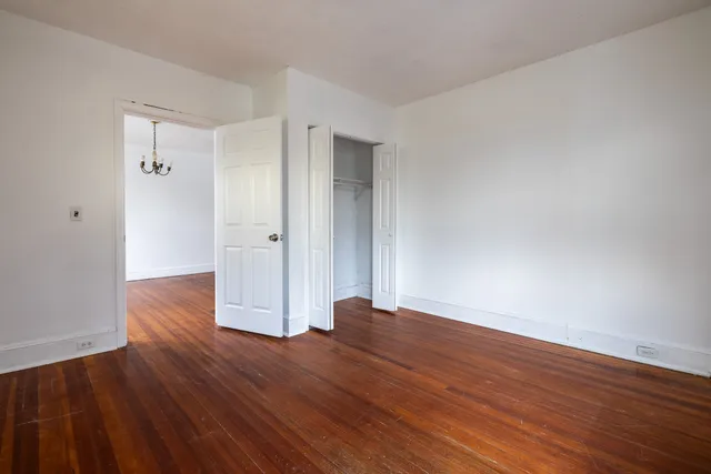 a view of empty room with wooden floor