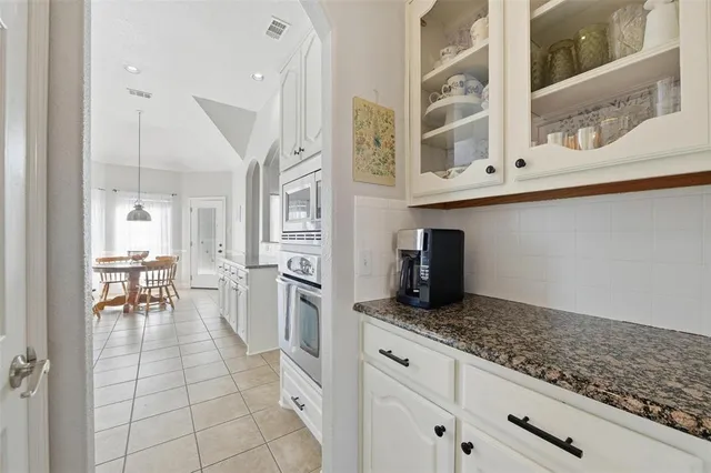 a kitchen with granite countertop a sink a stove and cabinets