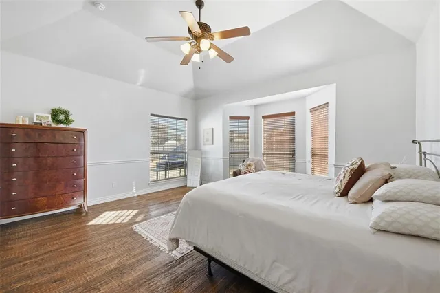 a bedroom with a large bed window and a ceiling fan