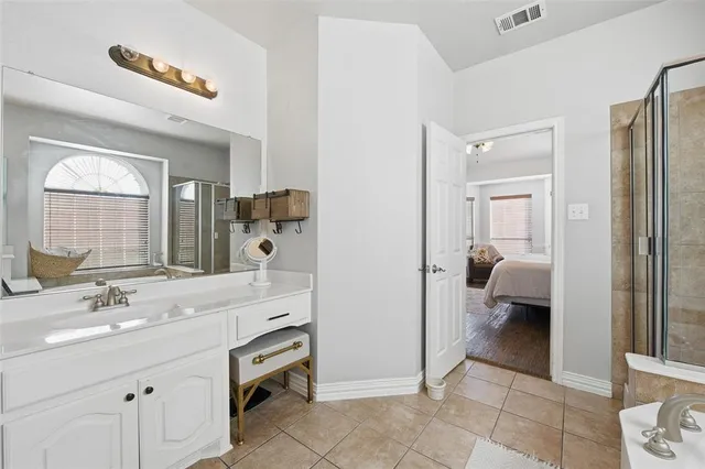 a en suite bathroom with a double vanity sink and a mirror