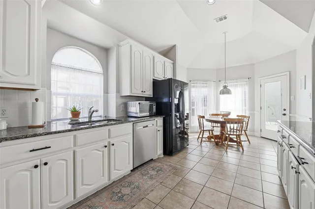 a kitchen with stainless steel appliances a refrigerator sink and cabinets