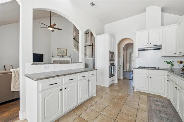 a spacious bathroom with a granite countertop sink mirror and cabinets