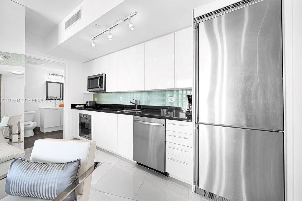 92 Southwest 3rd Street, Unit 4806 Miami, FL 33130 - Photo 2 of 20 a kitchen with stainless steel appliances granite countertop a refrigerator sink and white cabinets
