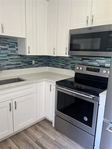 a kitchen with granite countertop a stove and a microwave