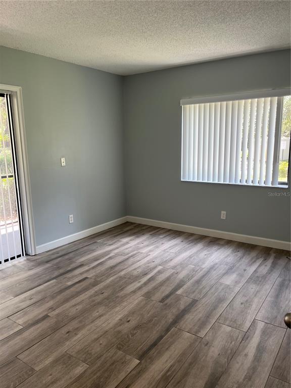 3300 Fox Chase Circle, Unit 213 Palm Harbor, FL 34683 - Photo 8 of 16 an empty room with wooden floor and windows