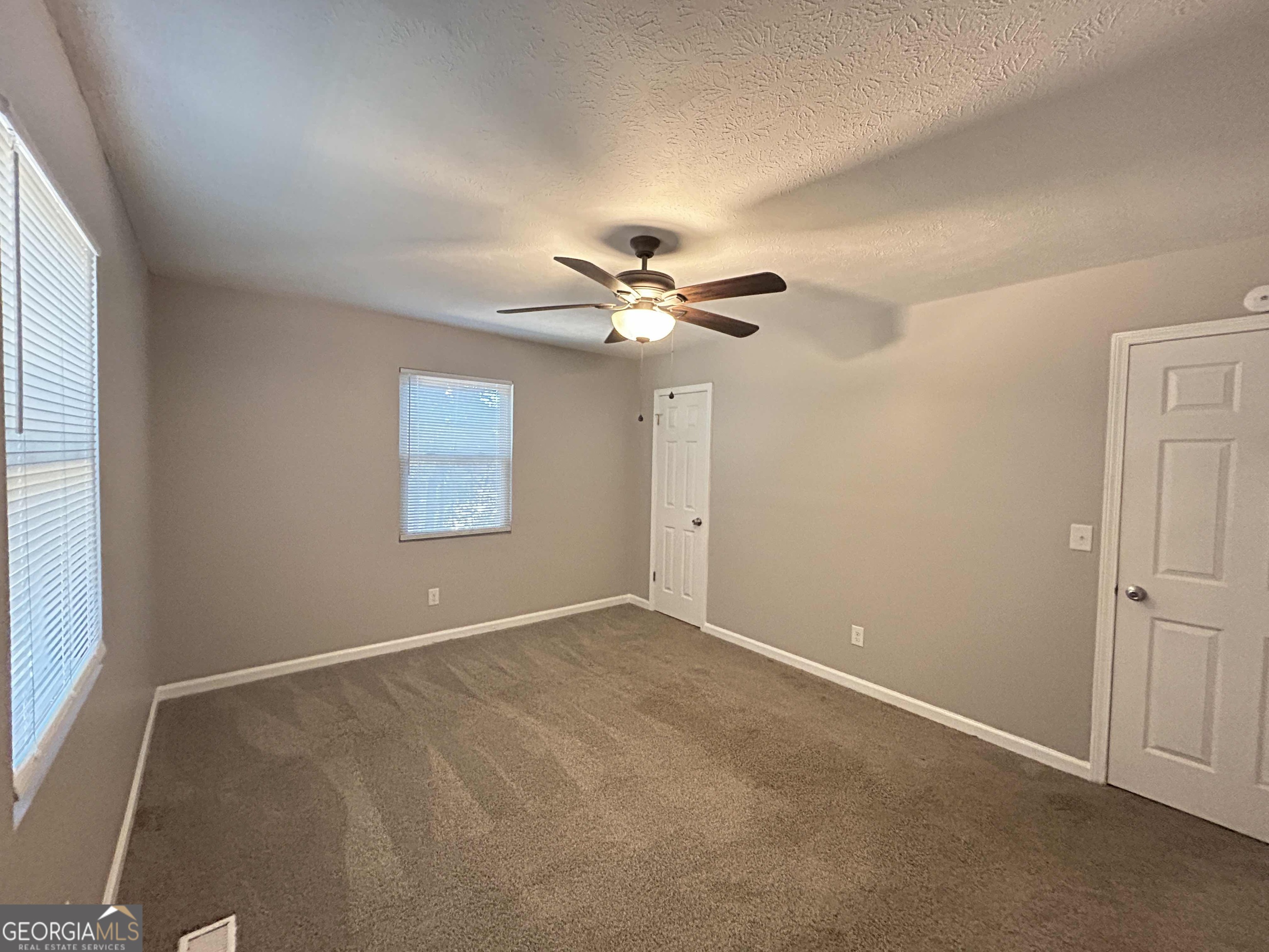 8937 Tweeddale Drive Winston, GA 30187 - Photo 23 of 26 an empty room with windows and fan