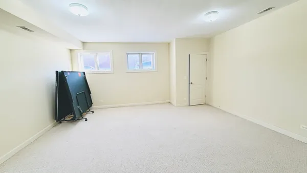 an empty room with a window and a ceiling fan