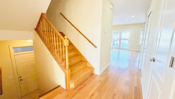 a view of a hallway with wooden floor and staircase
