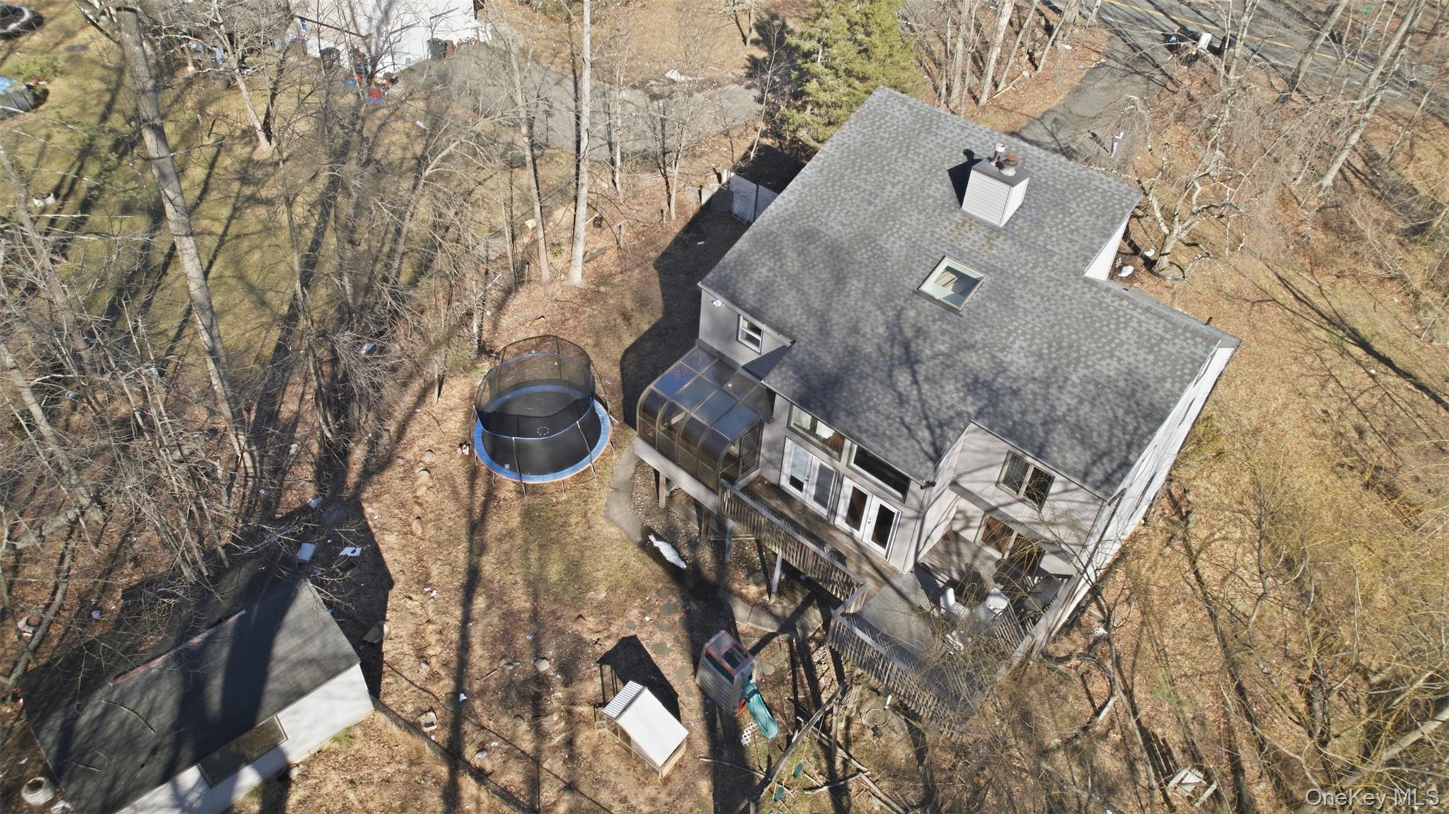 an aerial view of a house with a yard and wooden fence