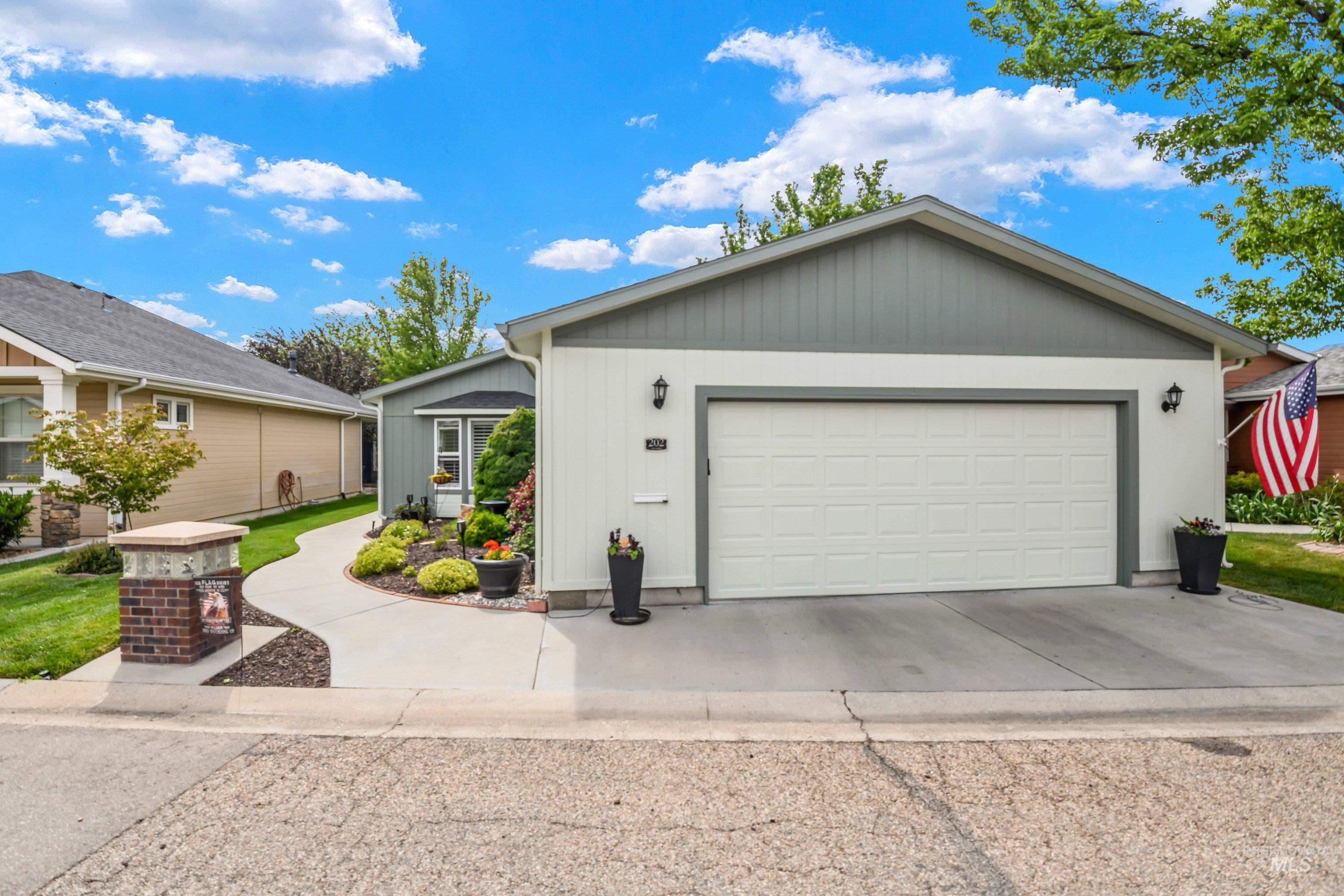 421 South Curtis Road, Unit 202 202 Boise, ID 83705 - Photo 1 of 41 Exterior featuring a combination of horizontal and vertical siding, a bay window with louvered shutters, an attached garage, and a concrete pathway